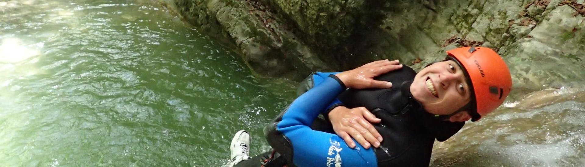 Einer der Teilnehmer der Canyoning-Tour "Discovery" - Canyon d'Angon von Térreo Canyoning rutscht eine natürliche Wasserrutsche hinunter.
