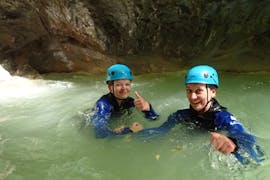 Ein Mann, der an der Canyoning-Tour "Discovery" - Canyon d'Angon von Térreo Canyoning teilnimmt, rutscht eine natürliche Wasserrutsche hinunter.