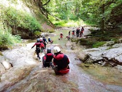 Friends are slidding down a natural slide during their Classic Canyoning in Canyon d'Angon, Talloires near Annecy with Takamaka Annecy.