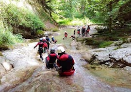 Freunde rutschen eine Naturrutsche hinunter während ihres Klassisches Canyoning im Canyon d'Angon, Talloires bei Annecy mit Takamaka Annecy.