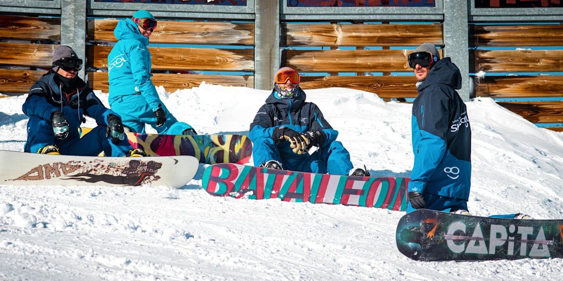 Snowboarders are sitting in the snow and waiting for the beginning of their Private Snowboarding Lessons - Afternoon with Ski Cool Val Thorens.