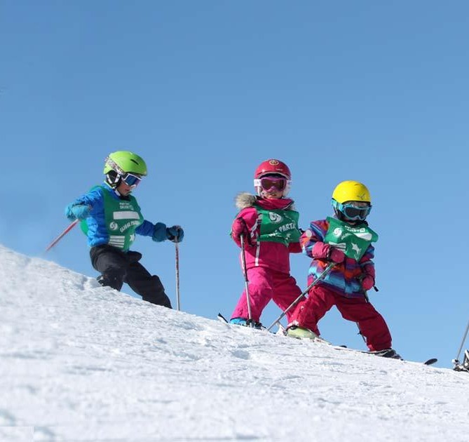 Jonge skiërs schaatsen een helling af tijdens een kinderskiles bij de ESF Les Orres.