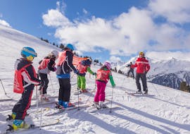 The ski instructor from Sertorelli Ski School Bormio is talking with the kids of the Kids Ski Lessons (4-12 y.) for Advanced - Full Day.