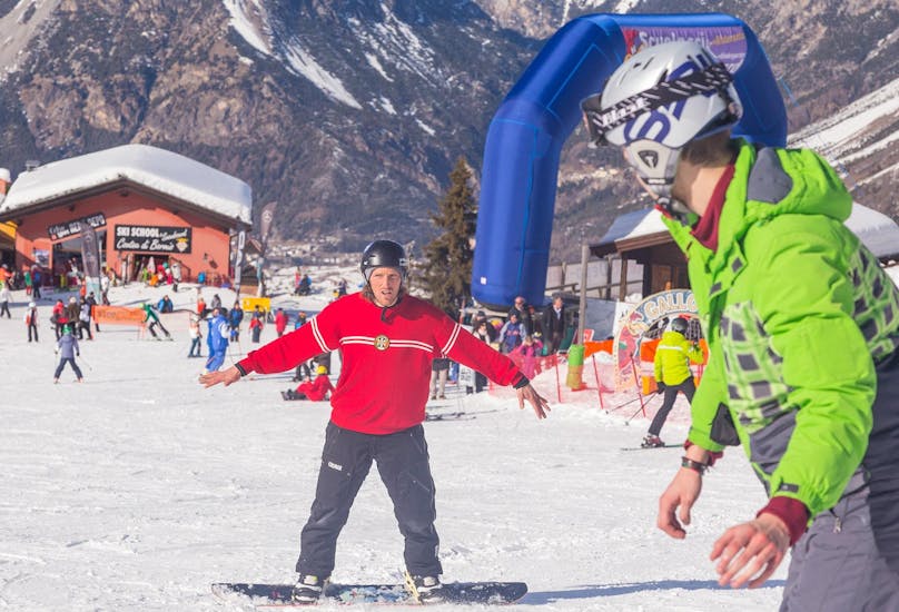 De snowboardleraar Sertorelli Skischool Bormio is met een deelnemer tijdens de privé snowboardles voor kinderen en volwassenen van alle niveaus.