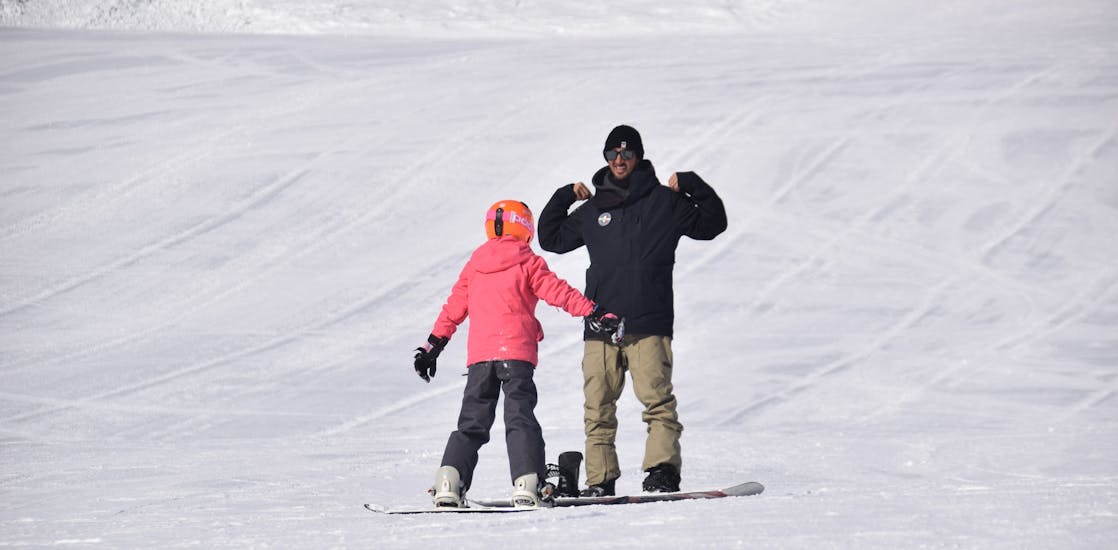 Snowboard instructor explaining the exercise to the participant of one of the private snowboarding lessons for kids and adults of all levels in Livigno.