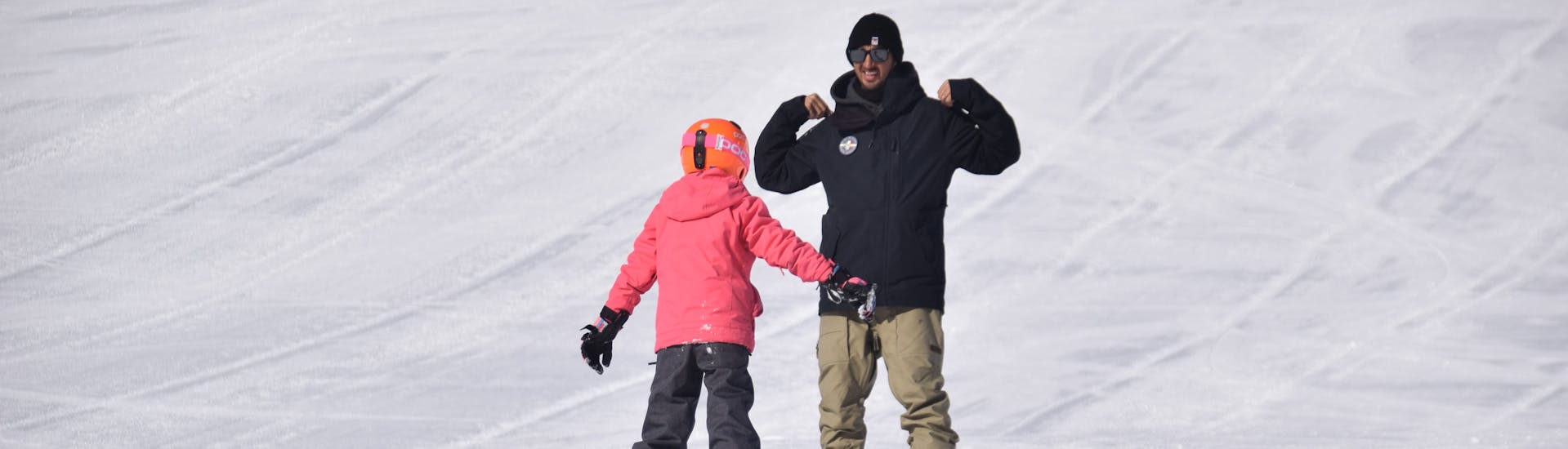 Istruttore di snowboard che spiega l'esercizio al partecipante di una delle lezioni private di snowboard per bambini e adulti di tutti i livelli a Livigno.