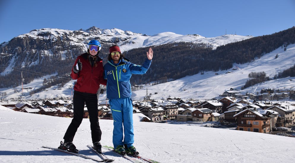 Moniteur de ski et participant sont sur les belles pistes de Livigno pour un des cours particuliers de ski pour enfants de tous niveaux.