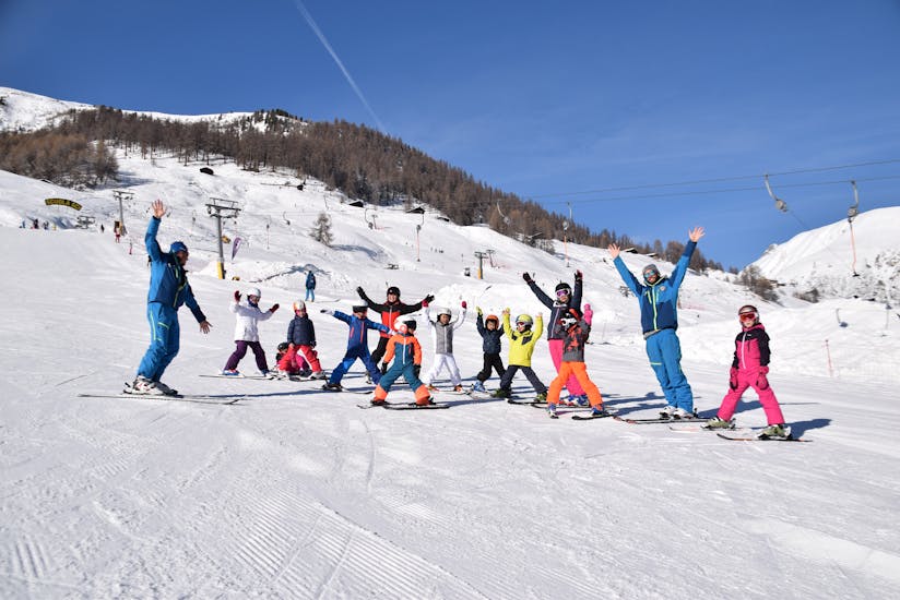 Tout le monde est heureux à Livigno pendant un des cours de ski pour enfants de tous niveaux.