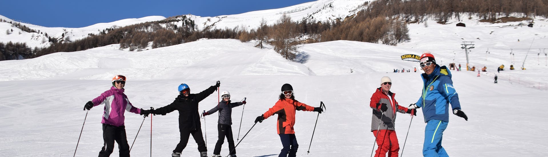 Une famille passant sa journée sur la neige ensemble à Livigno pendant un des cours particuliers de ski pour familles et amis.