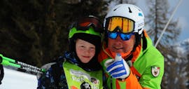 Les cours particuliers de ski pour enfants - tous niveaux de l'école de ski Aevolution de Folgarida viennent de se terminer, le professeur et l'enfant sourient à la caméra.