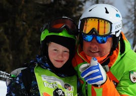 Private Ski Lessons for Kids - All Levels of the Folgarida Aevolution Ski School are just finished, teacher and child smile at the camera.