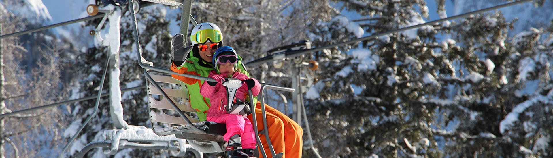 Ski instructor and kid on the chairlift starting one of the private ski lessons for kids of all levels in Folgarida.