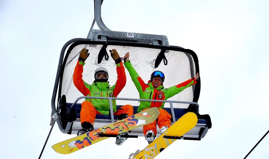 Snowboard instructeurs op een stoeltjeslift voor een van de privé snowboardlessen voor kinderen en volwassenen van alle niveaus in Folgarida.