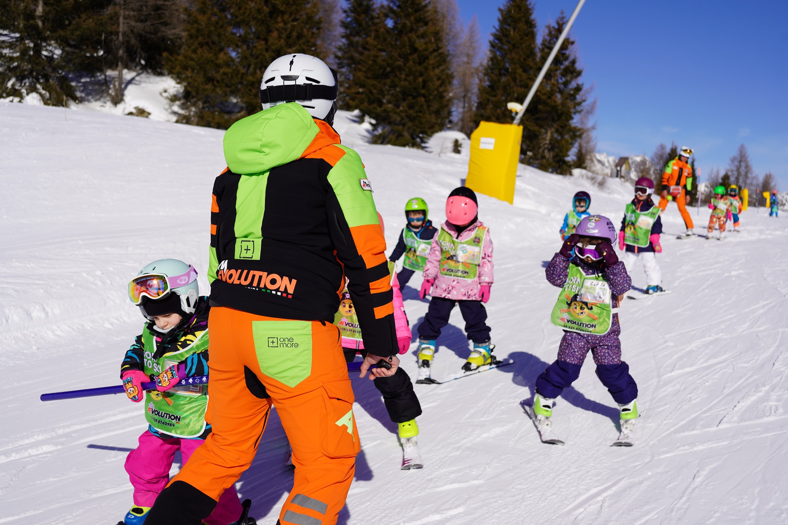 Les enfants se tapent la main pendant l'un des cours de ski pour enfants de tous niveaux à Folgarida.