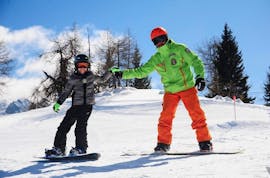Pugno contro pugno sulle piste di Folgarida durante una delle lezioni di snowboard per bambini e adulti di tutti i livelli.