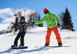 Fist bump on the slopes of Folgarida during one of the snowboarding lessons for kids and adults of all levels.