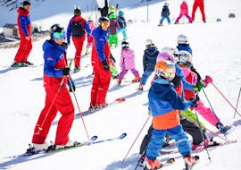 Laughing children pose for the photo in the ski course for children (4-13 years) - advanced ski school Silvretta Galtür.