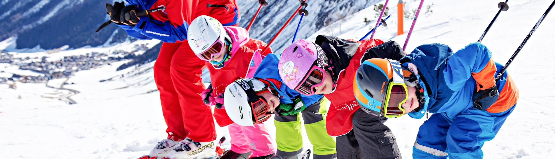 Laughing children pose for the photo in the ski course for children (4-13 years) - advanced ski school Silvretta Galtür.