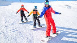 Snowboarder fahrt schnell die Piste hinunter im Snowboardkurs für Kinder & Erwachsene - Alle Levels.