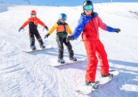 Snowboarders ride fast down the slopes in snowboard lessons for kids & adults - All levels.