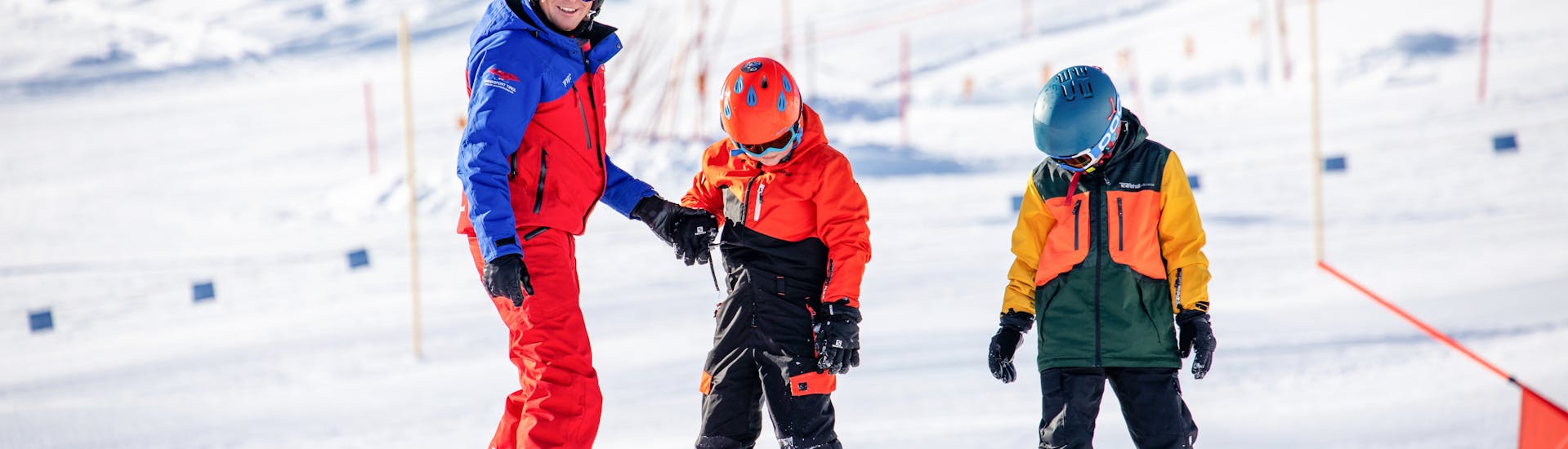 Les snowboarders dévalent les pentes à toute vitesse pendant les cours de snowboard pour enfants et adultes - tous niveaux.