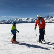 Un moniteur de ski et un enfant sur les pistes de Madonna di Campiglio pendant un des cours de ski pour enfants (4-12 ans) pour les débutants.