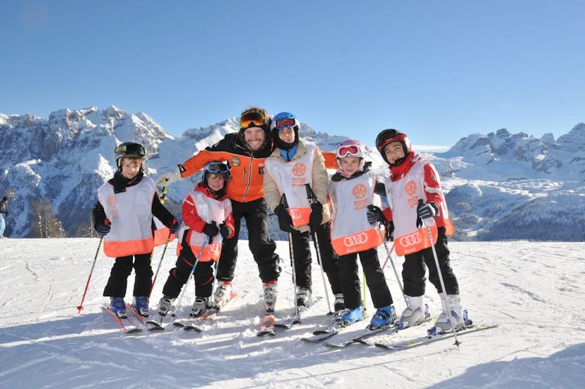 Kinderen gaan op de foto met de skileraar in Madonna di Campiglio tijdens een van de Kinderskilessen "VIP" (4-12 jaar) - Halve Dag