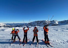 Des enfants regardent les montagnes à Madonna di Campiglio pendant l'un des cours particuliers de ski pour enfants de tous âges.
