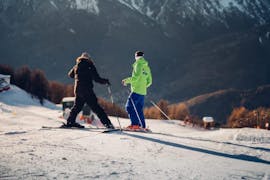 Twee volwassenen genieten van de op maat gemaakte privé skilessen voor volwassenen - alle niveaus onder begeleiding van een instructeur van de skischool Scuola di Sci B.foxes.