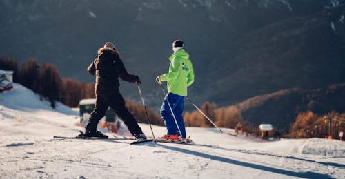 Privé skilessen voor volwassenen van alle niveaus met Ski School B.Foxes Bardonecchia Twee volwassenen genieten van de op maat gemaakte privé skilessen voor volwassenen - alle niveaus onder begeleiding van een instructeur van de skischool Scuola di Sci B.foxes.