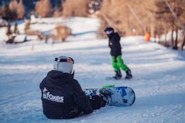 A little snowboarder is having fun during the Private Snowboarding Lessons for Kids & Adults - All Levels and benefits from the full attention of an instructor from the school Scuola di Sci B.foxes.