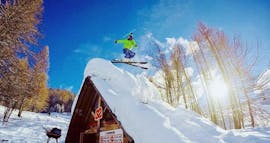 Un skieur essaye de nouvelles figures pendant son Cours particulier de ski freestyle - Tous âges qu'il a appris de son moniteur de ski de l'école de ski Scuola di Sci B.foxes.