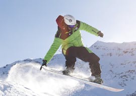Snowboard instructor jumping in Bormio during one of the Private Snowboarding Lessons for Kids & Adults of All Levels.