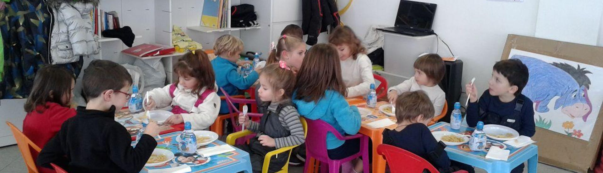 Bambini mangiano durante la pausa a Bormio durante il Mini Club (3-10 anni) con Pranzo.