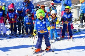 Een kind heeft plezier op de pistes van het Via Lattea skiresort in Sestriere tijdens de Kinderskilessen (5-12 j.) - Gevorderd georganiseerd door de skischool Scuola di Sci Olimpionica.
