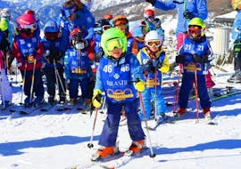 Un enfant s'amuse sur les pistes de la station de ski Via Lattea à Sestrières pendant ses Cours de ski Enfants (5-14 ans) pour Skieurs expérimentés organisés par l'école de ski Scuola di Sci Olimpionica.