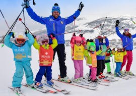 A group of young skier is having fun with the ski instructor of the Kids Ski Lessons (5-12 y.) - Beginner organized by the ski school Scuola di Sci Olimpionica in Sestriere.