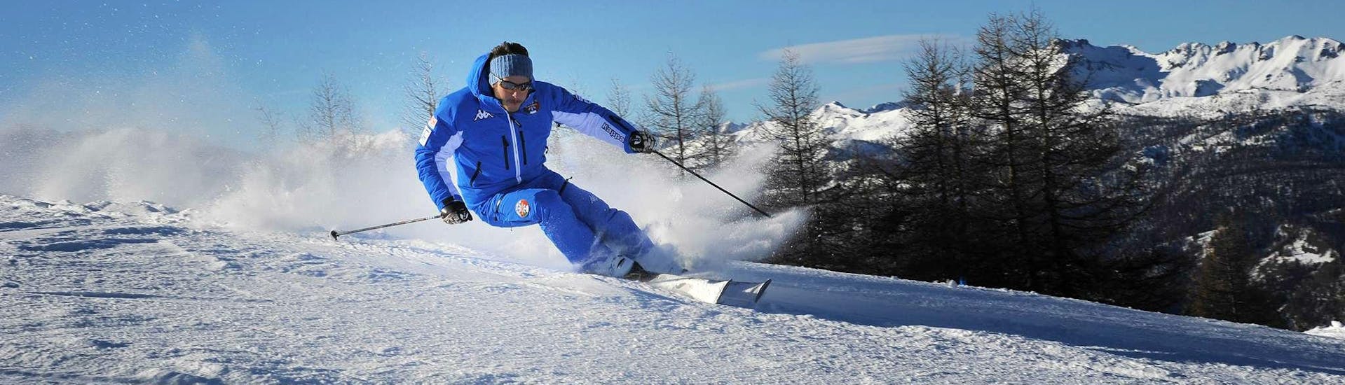 Een ski-instructeur van de skischool Scuola di Sci Olimpionica in Sestriere demonstreert de juiste carvingtechniek tijdens een van de Skilessen voor Volwassenen - Gevorderd.