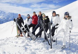 A group of skiers is having fun on the slopes of the Via Lattea ski resort in Sestriere during the Ski Lessons for Adults - Advanced organized by the ski school Scuola di Sci Olimpionica.