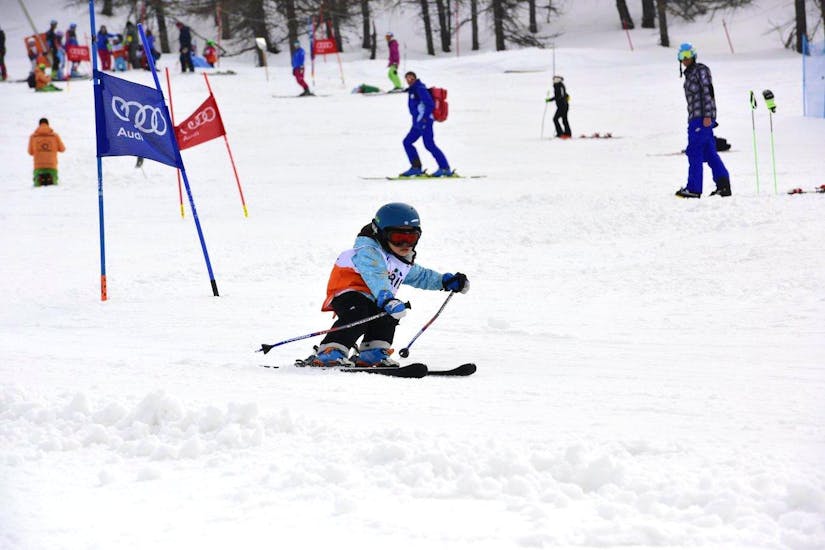 Een jonge skiër probeert om een piste in het Via Lattea skiresort in Sestriere te beheersen tijdens een van de Privé Skilessen voor Kinderen - Alle Niveaus met de skischool Scuola di Sci Olimpionica.