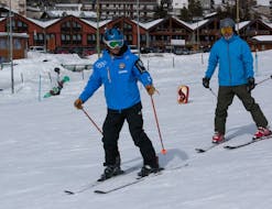 Un moniteur de ski et un participant à Sestrières pendant un Cours particulier de ski Adultes pour Tous niveaux avec Scuola di Sci Olimpionica.