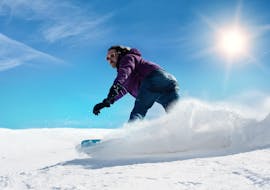 Uno snowboarder sta scendendo una pista a Sestriere nel comprensorio sciistico della Via Lattea durante una delle Lezioni private di snowboard - Tutte le età e livelli organizzate dalla Scuola di Sci Olimpionica.