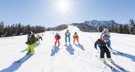 Eine Gruppe junger Skifahrer rast in ihrem Kinder-Skikurs für fortgeschrittene Skifahrer mit der Schneesportschule Balderschwang die Piste hinunter. 