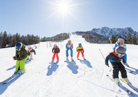 A group of young skiers race down the slope in their kids ski lessons for advanced skiers with the Schneesportschule Balderschwang. 
