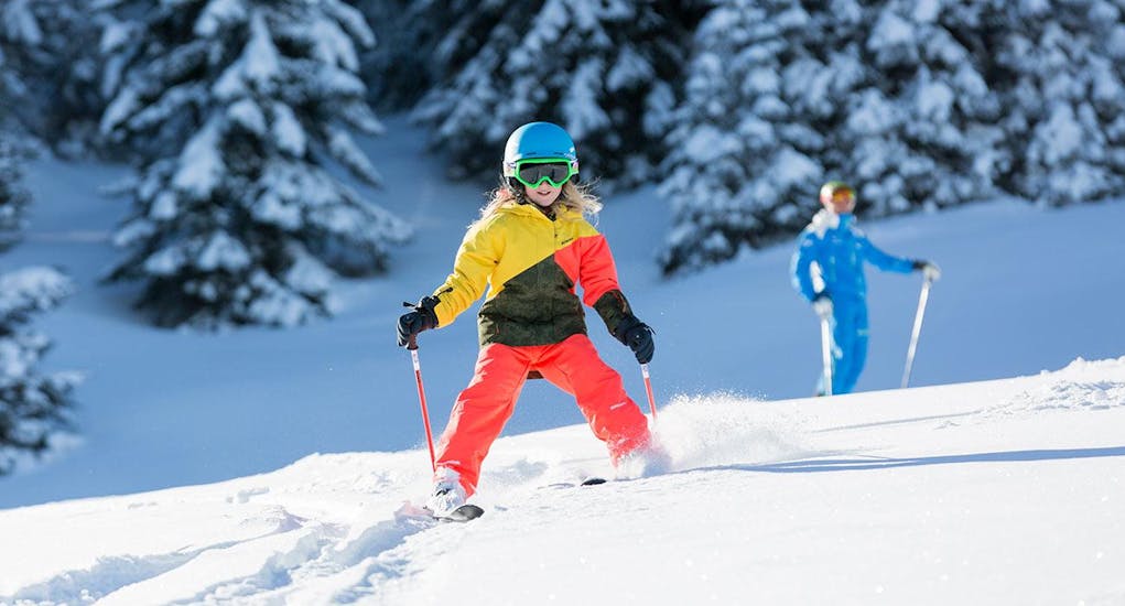 A young skier races down the slopes during her private ski lessons for kids for all levels with the Schneesportschule Balderschwang. 
