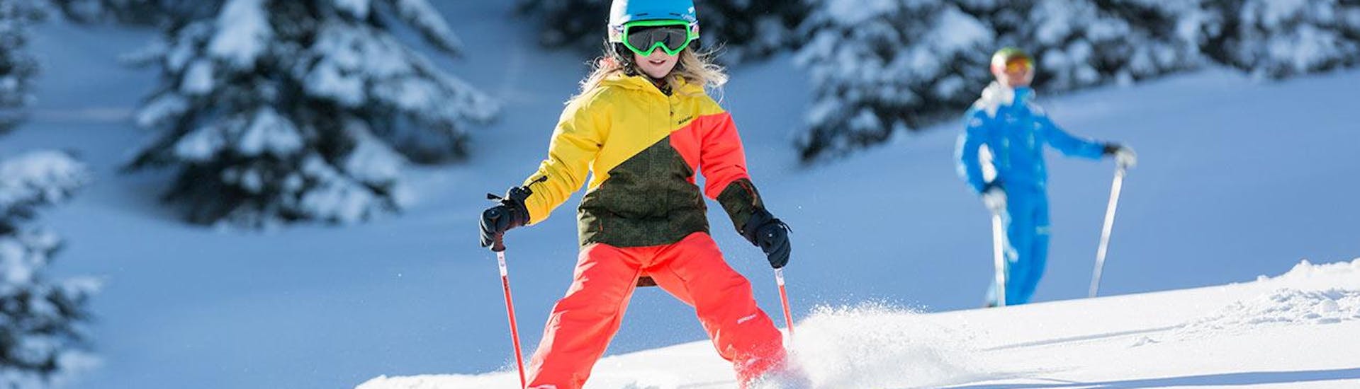 Eine junge Skifahrerin rast während ihrem privaten Skikurs für Kinder für alle Levels mit der Schneesportschule Balderschwang die Pisten hinunter.