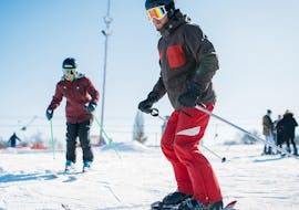 Een volwassen skiër neemt deel aan de skilessen voor volwassenen voor alle niveaus bij de Schneesportschule Balderschwang en skiet de piste af