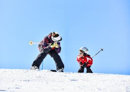 A young skier is paying attention to the ski instructor during the Private Ski Lessons for Kids for All Levels organized by the ski school YES Academy Sestriere.
