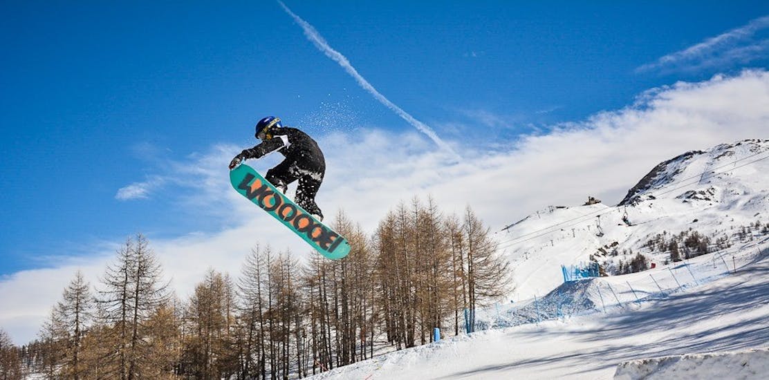teenager jumping with snowboard during private snowboard lessons for kids of all levels yes academy Sestriere.