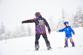 Un snowboardeur prête attention au moniteur de snowboard lors des Cours particuliers de snowboard organisées par l'école de ski YES Academy de Sestrières.